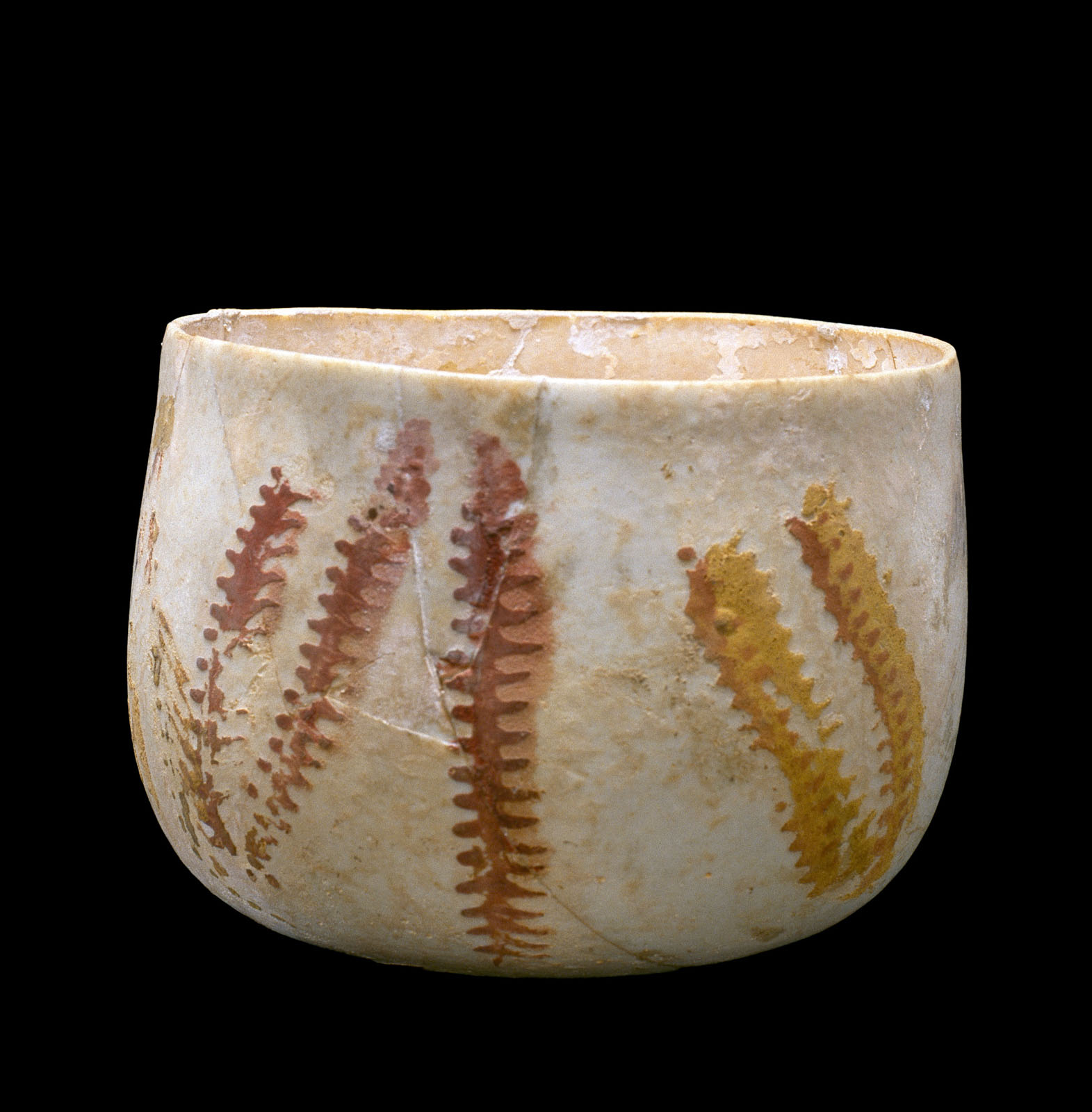 Weathered, round, pale cup with reddish-brown fern-like patterns around the exterior