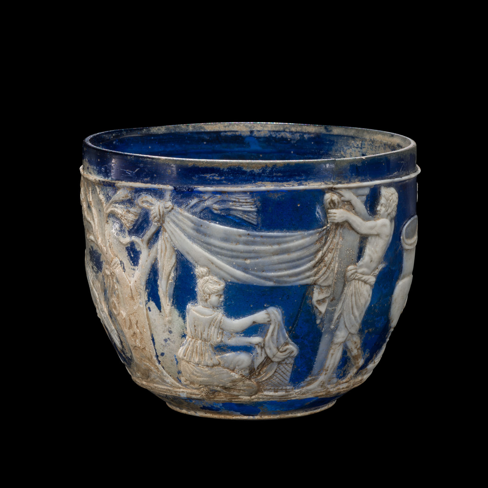 Round, deep blue bowl featuring raised figures in white, depicting a classical scene