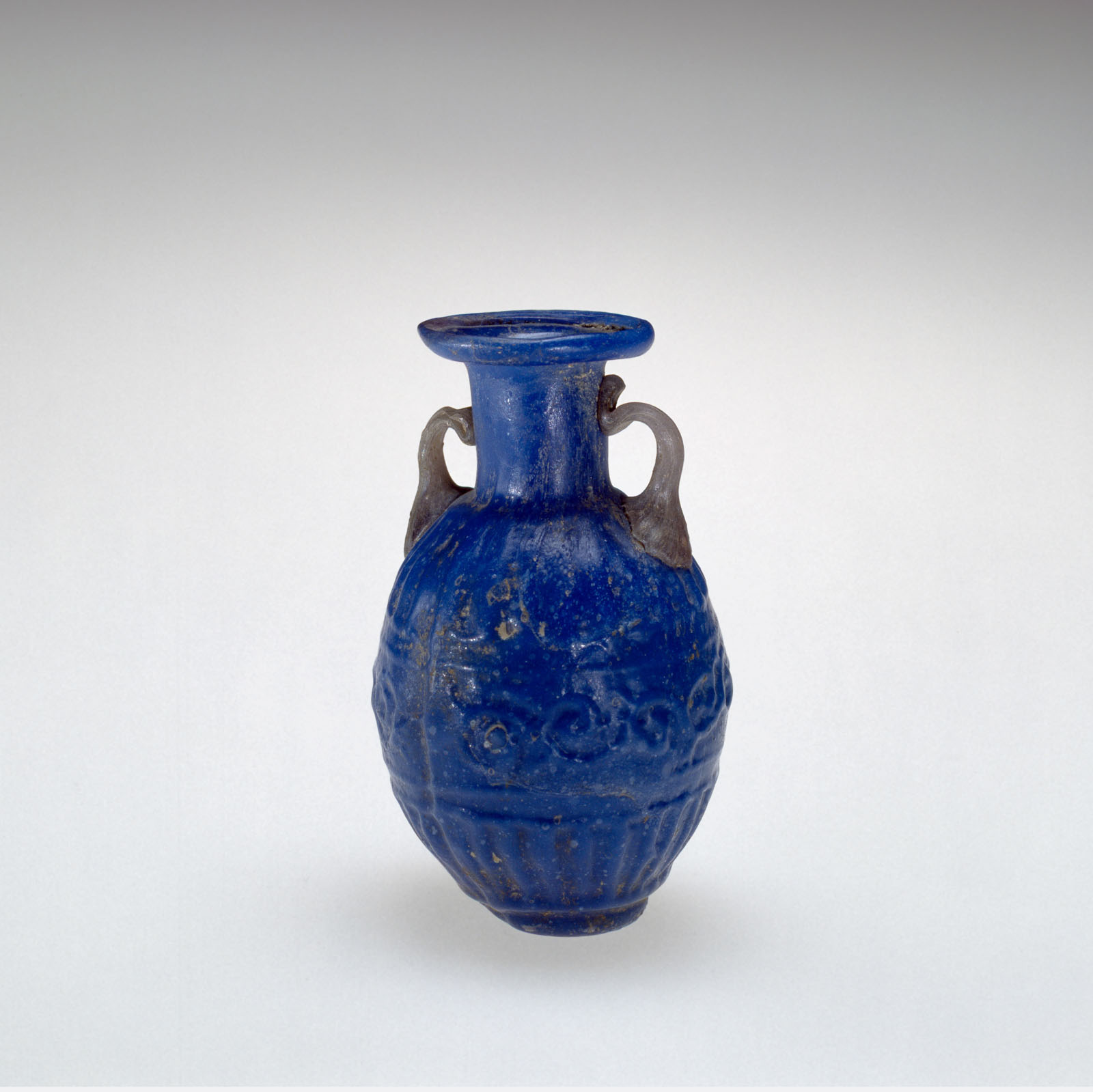 Small, cobalt blue vase with twin handles and decorative patterns around its body