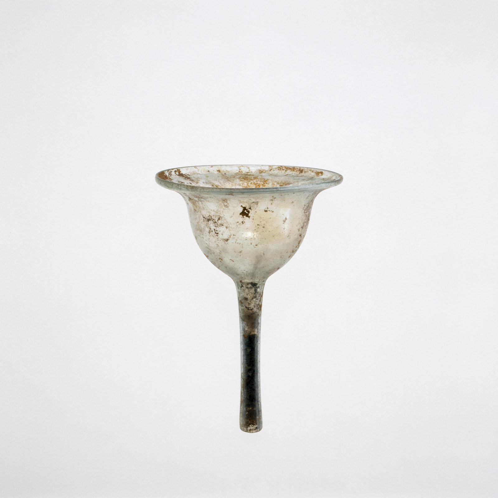 Mottled, clear glass funnel with a flared, open top and a tapered stem, showing evidence of aging