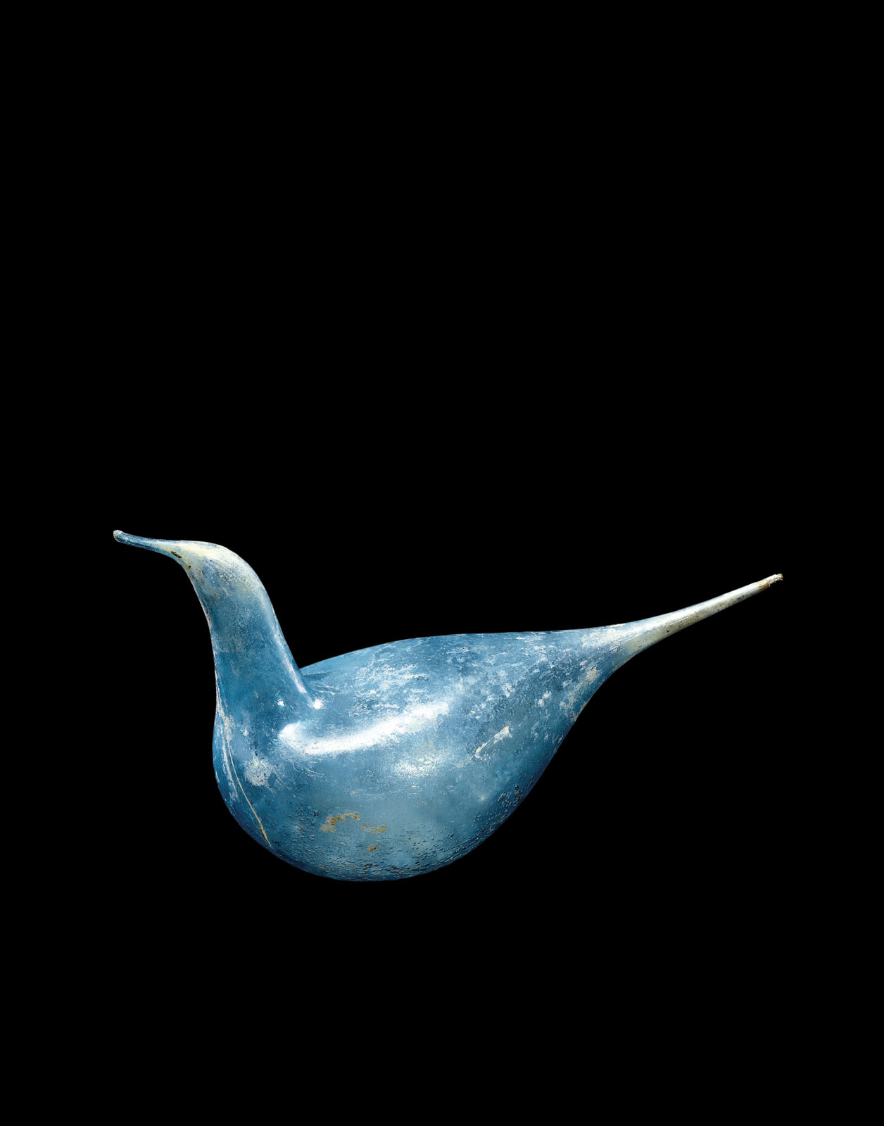 Bird-shaped glass object with sky blue hue, light-colored tapered tail, and pointed beak