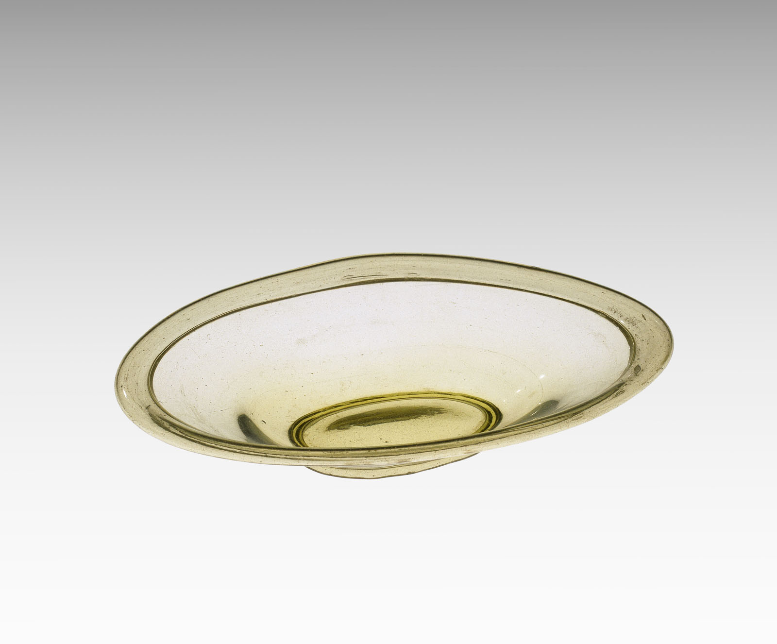 Uneven, shallow, pale amber glass bowl with a thin, pronounced rim